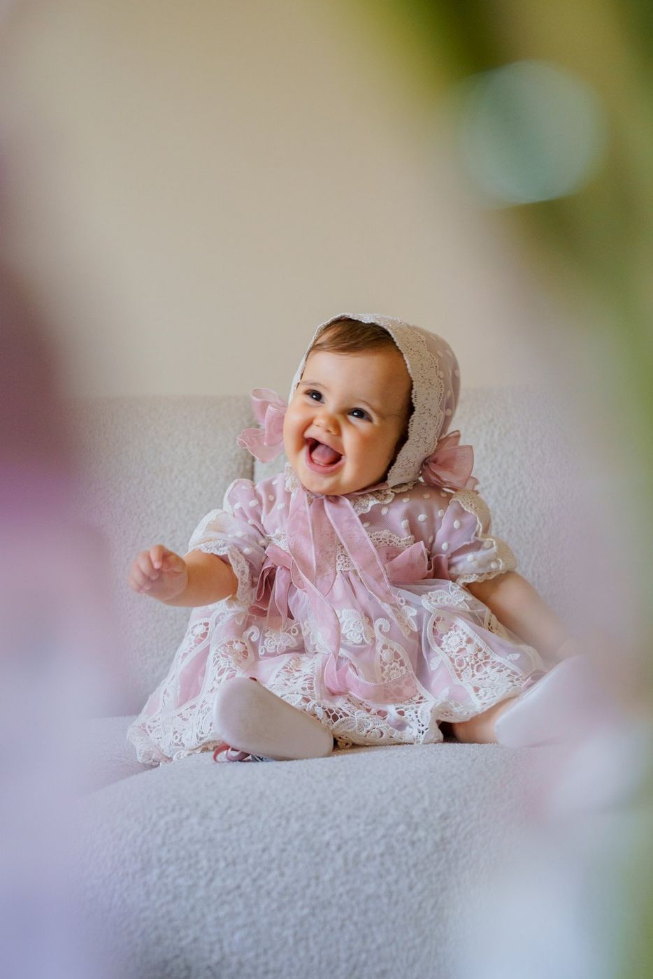 Baby laughing in a pink bonnet