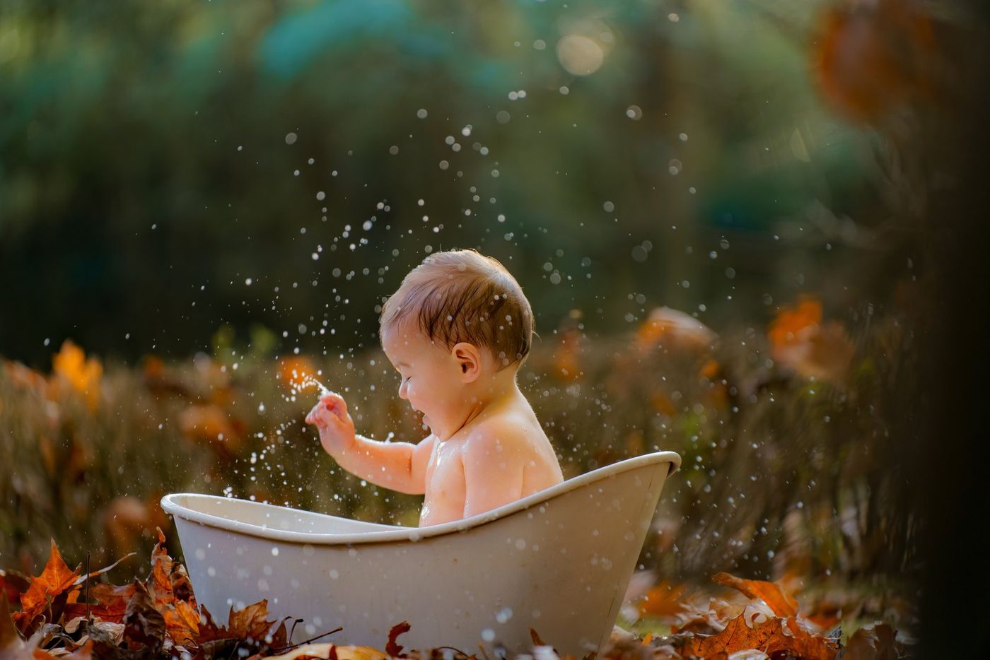 Baby splashing water in an autumn session
