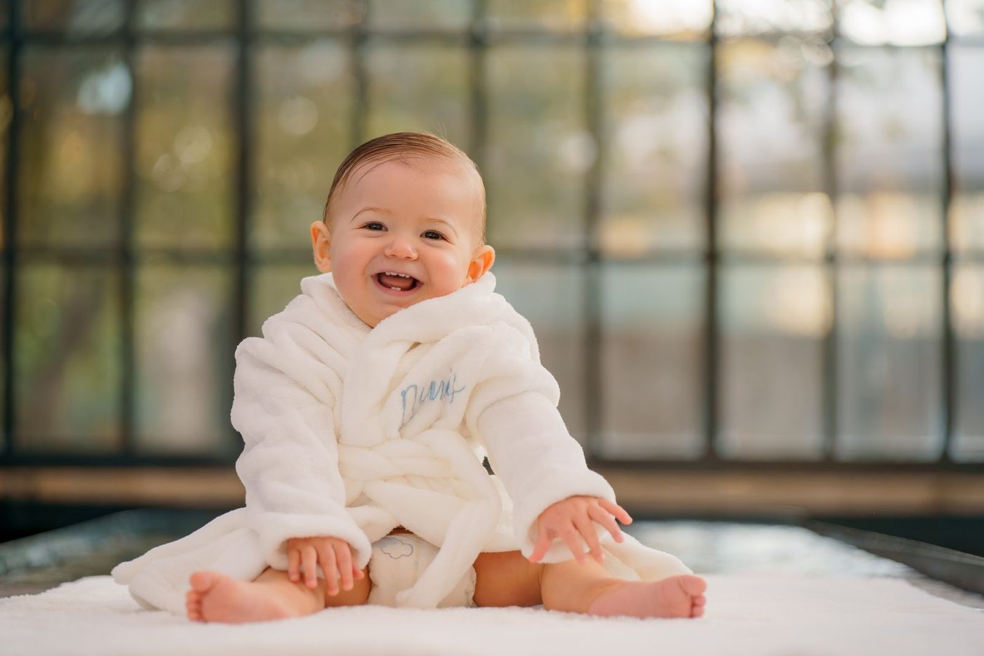 Baby smiling in a white bathrobe