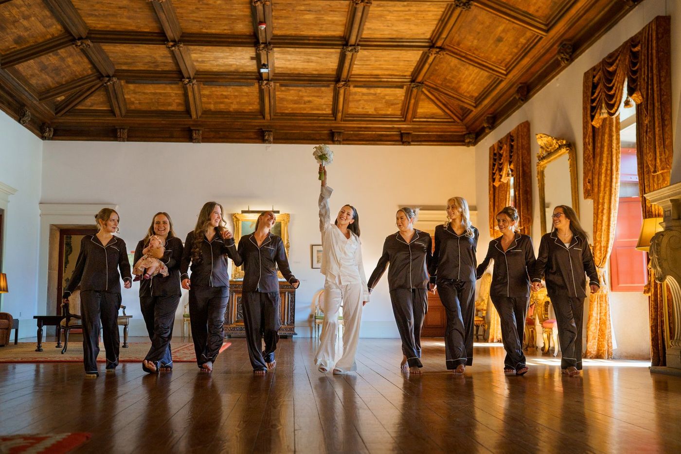 Bride and bridesmaids in pyjamas in an old hall