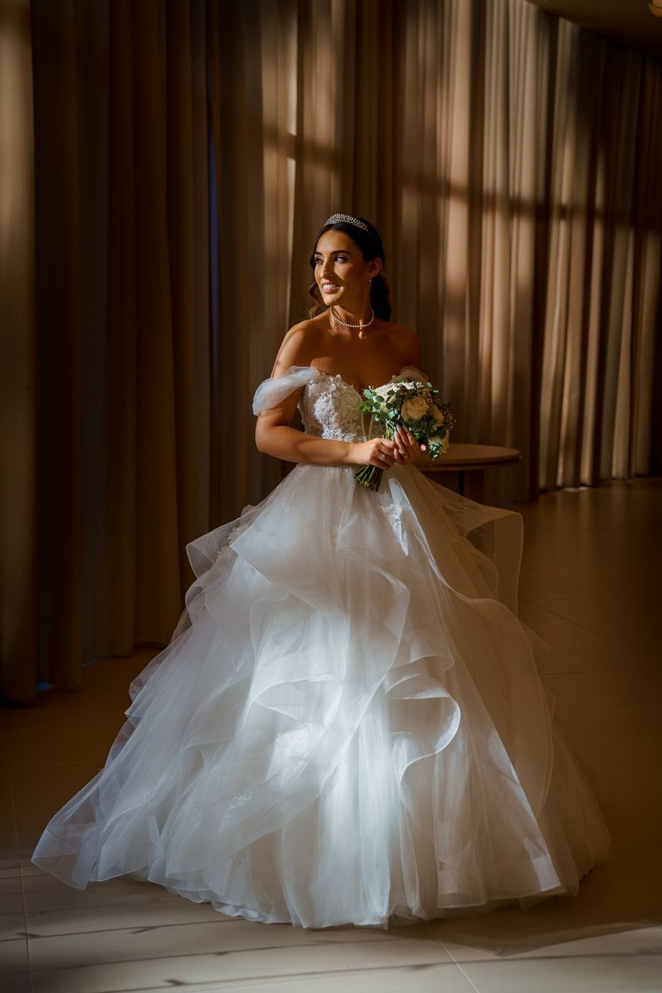 Bride with her bouquet in side light