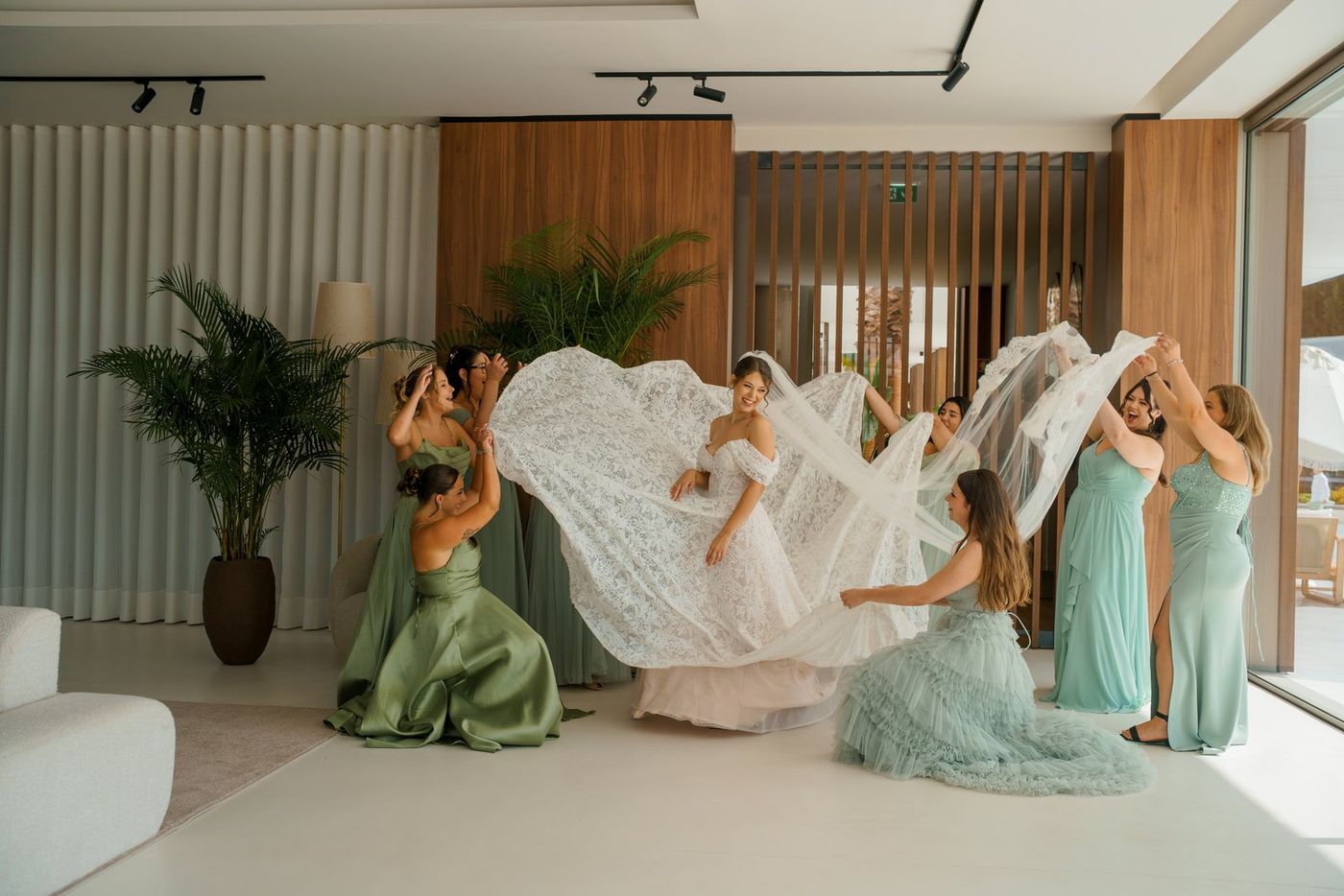 Bridesmaids lifting the train of the dress