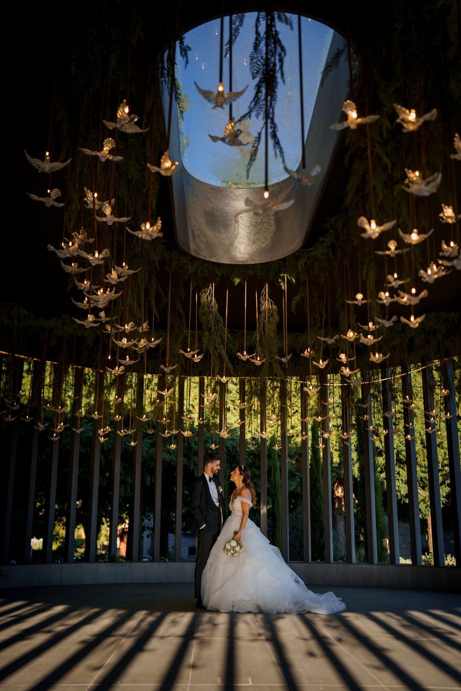 Bride and groom at night beneath hanging birds