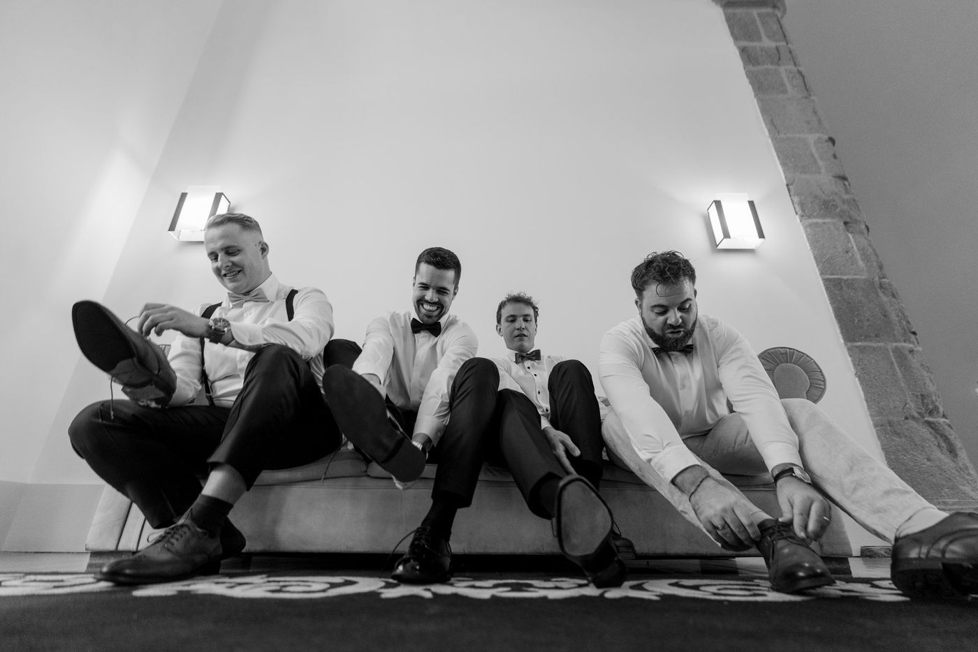 Groom and groomsmen putting on their shoes