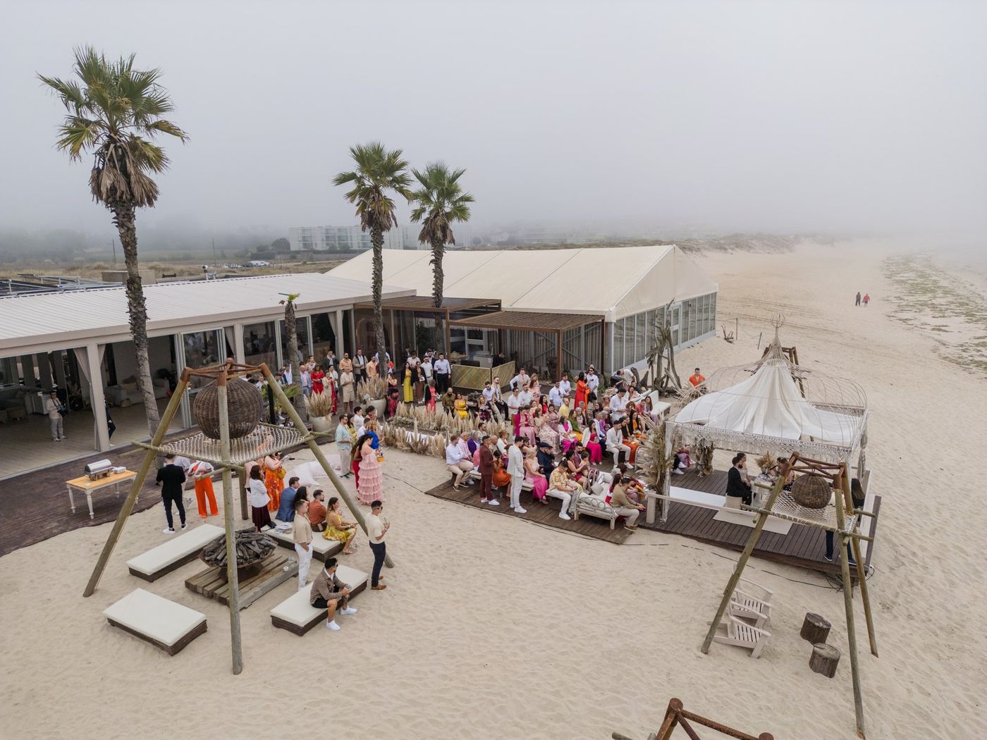Beach ceremony in the mist, seen from a drone