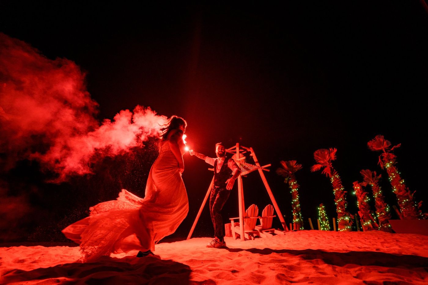 Bride twirling in red smoke on the beach