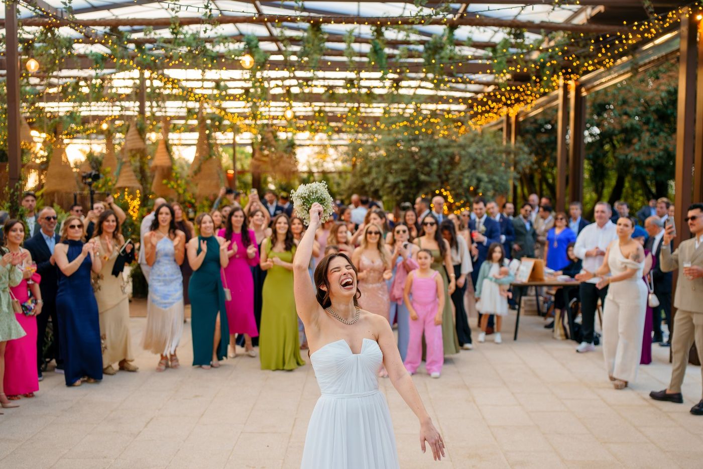 Bride throwing the bouquet at night