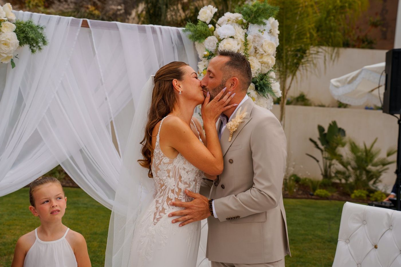 The couple's kiss, with a little girl pulling a face