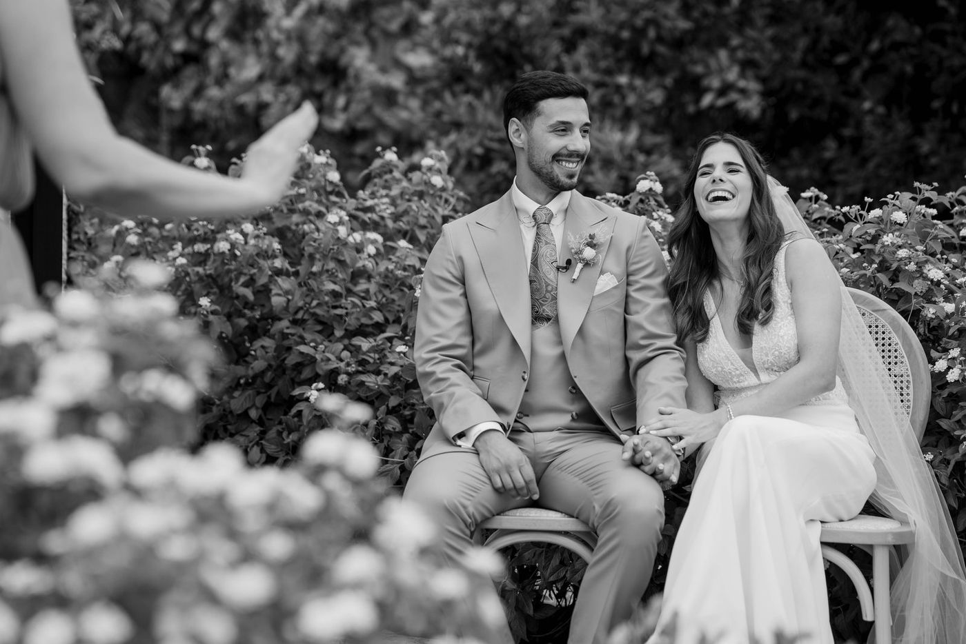 Bride and groom laughing at the ceremony, in black and white