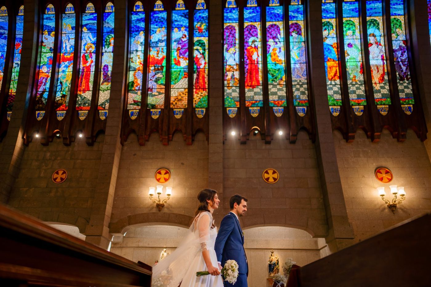Bride and groom at the altar beneath stained glass