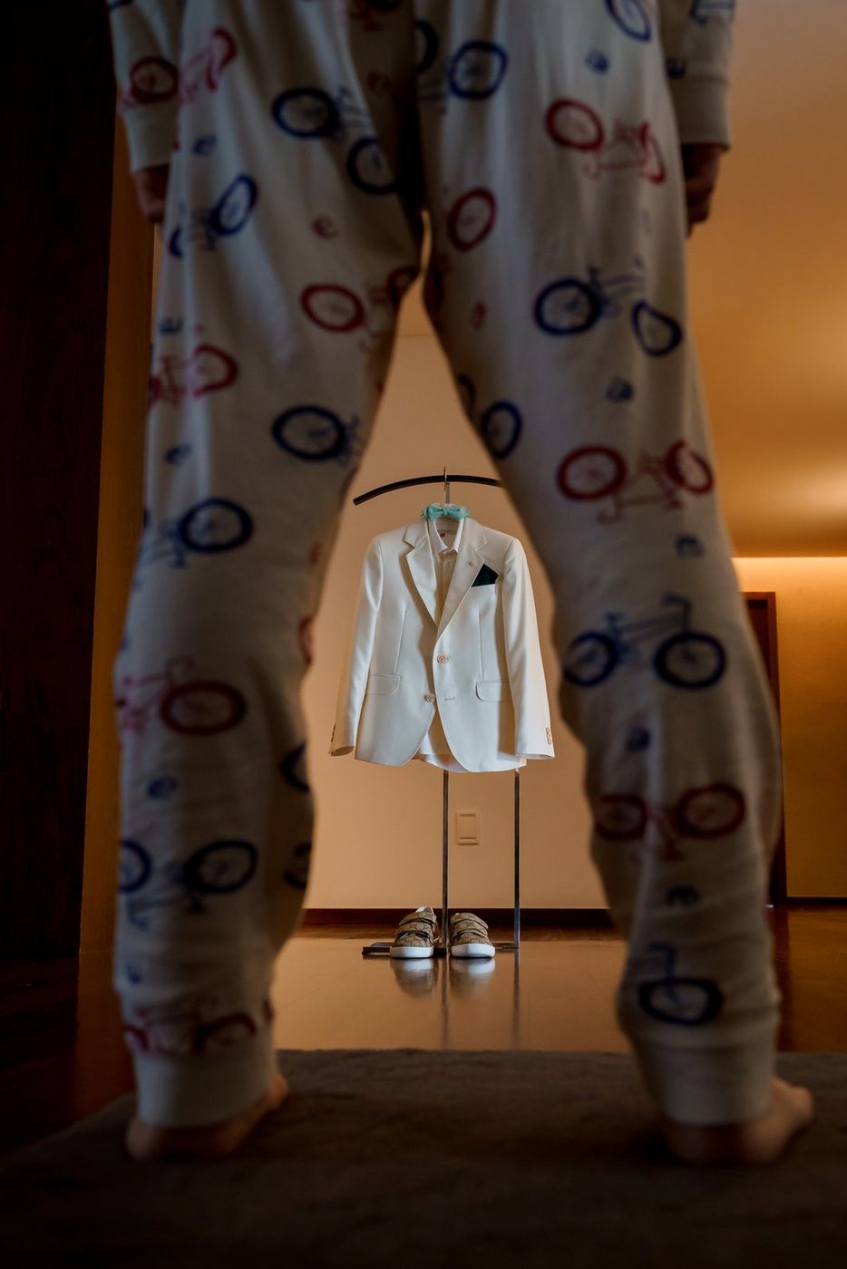 Communion suit hanging up, seen between the boy's legs