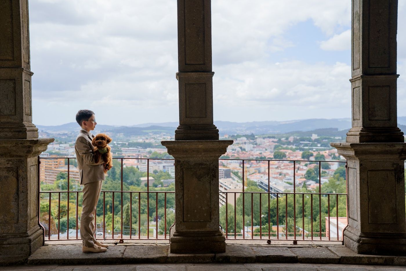 Boy on a balcony with the city behind