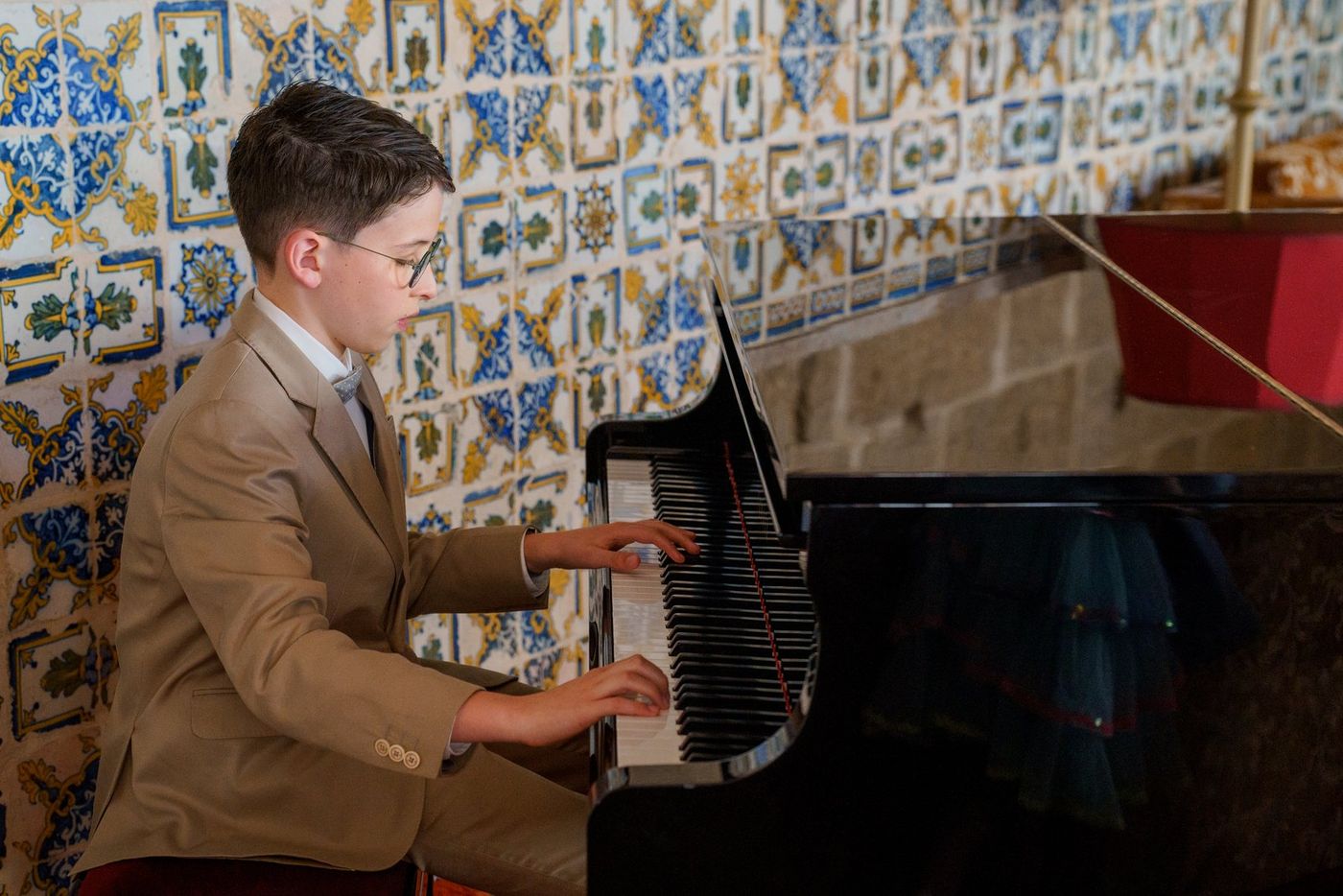Boy at the piano, with Portuguese tiles behind