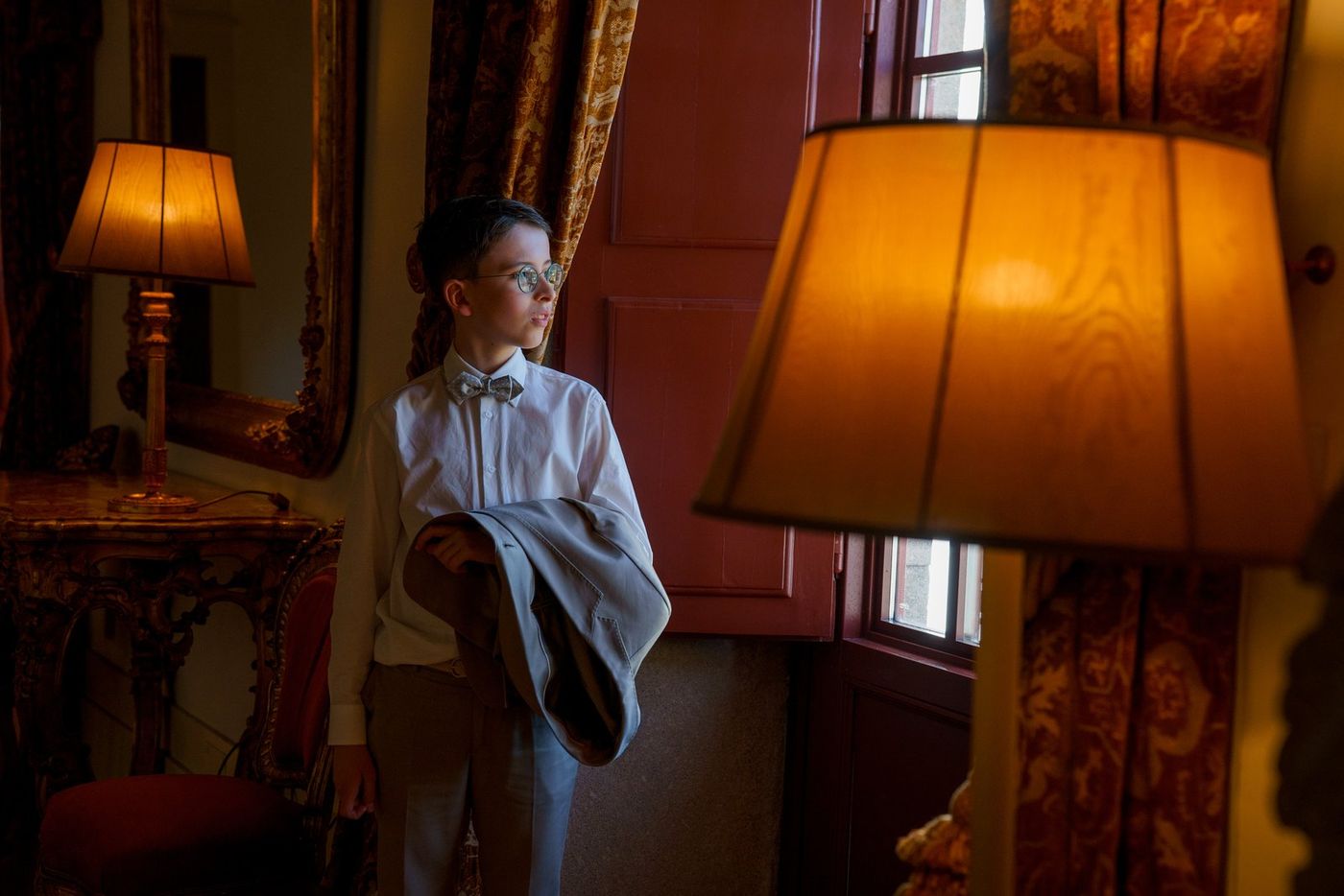 Boy at the window between lamps