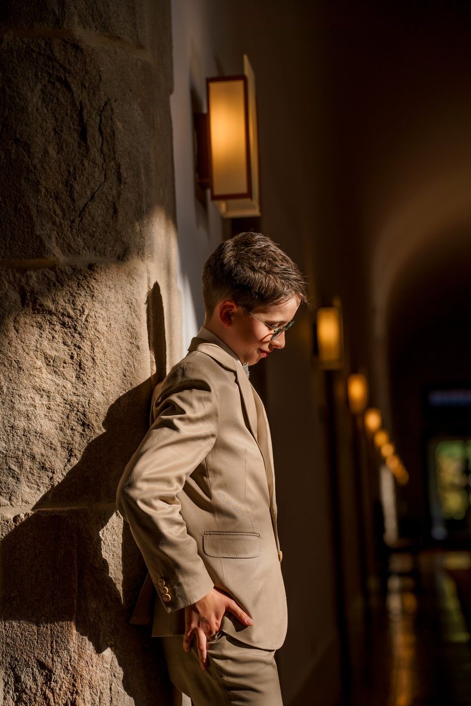 Boy leaning against a stone wall