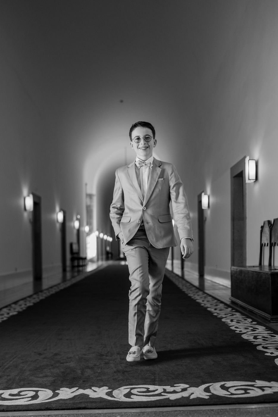 Boy walking down a corridor, in black and white