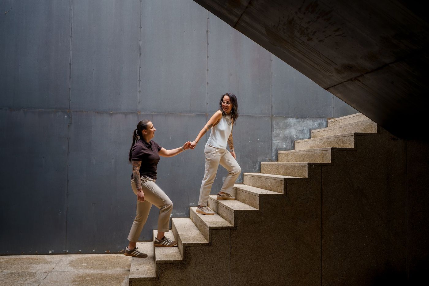 Couple climbing steps by a blue wall