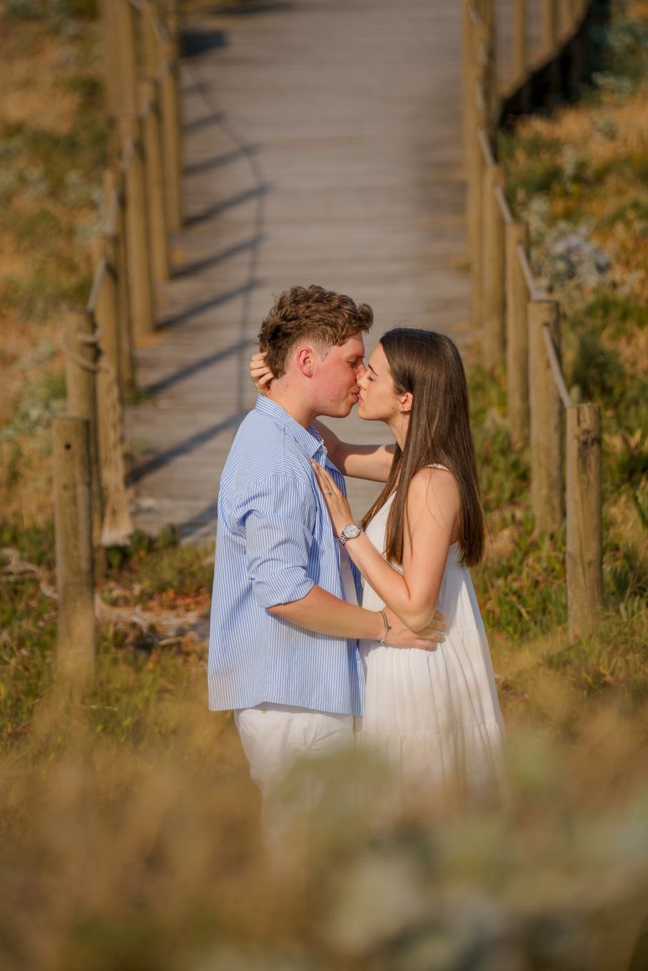 Couple kissing on a wooden boardwalk