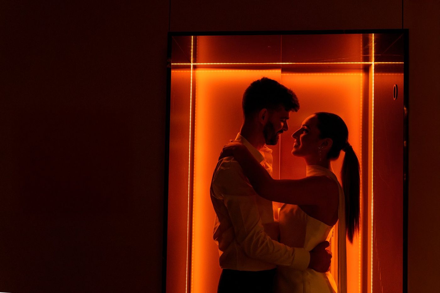 Couple in an elevator bathed in orange light