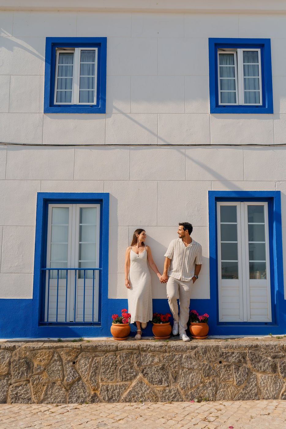 Couple by a white and blue house