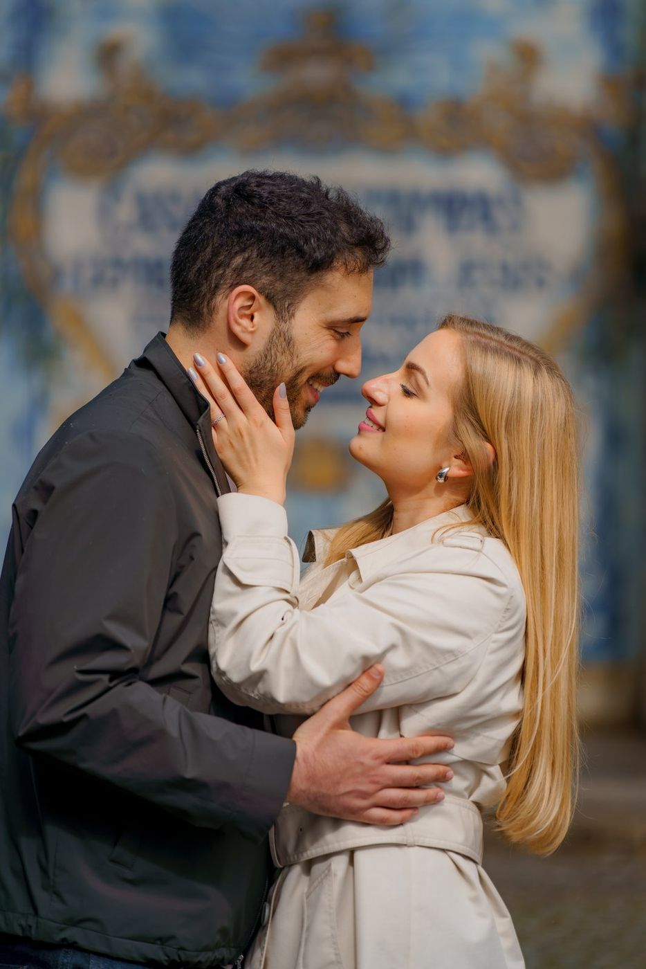 Couple cheek to cheek, with Portuguese tiles behind