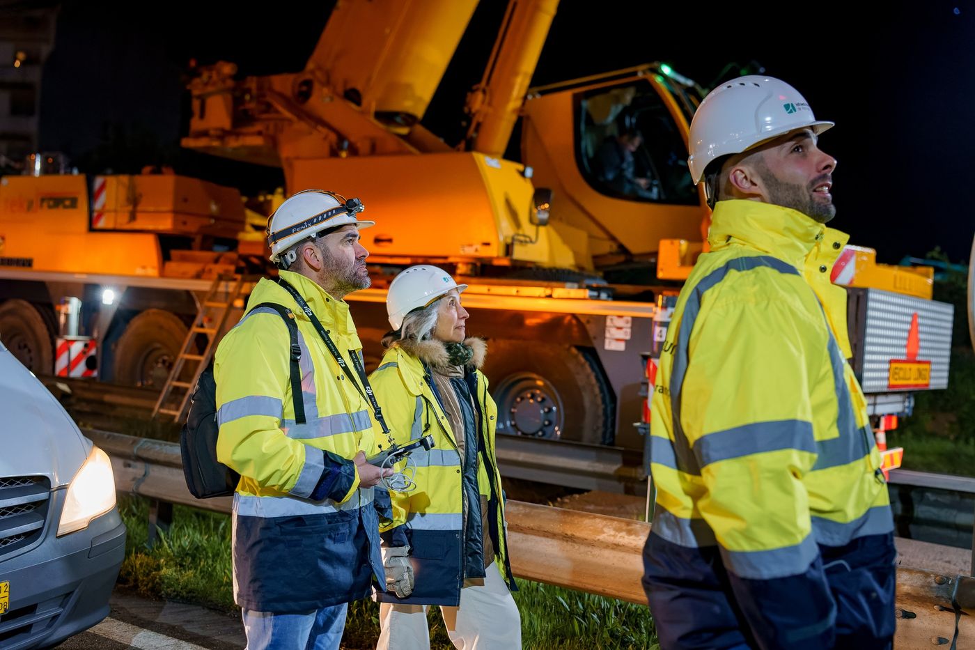 Night construction crew beside a crane