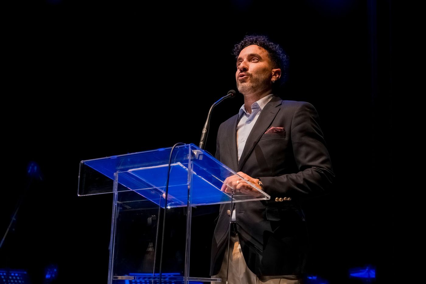 Speaker at a glass lectern on stage