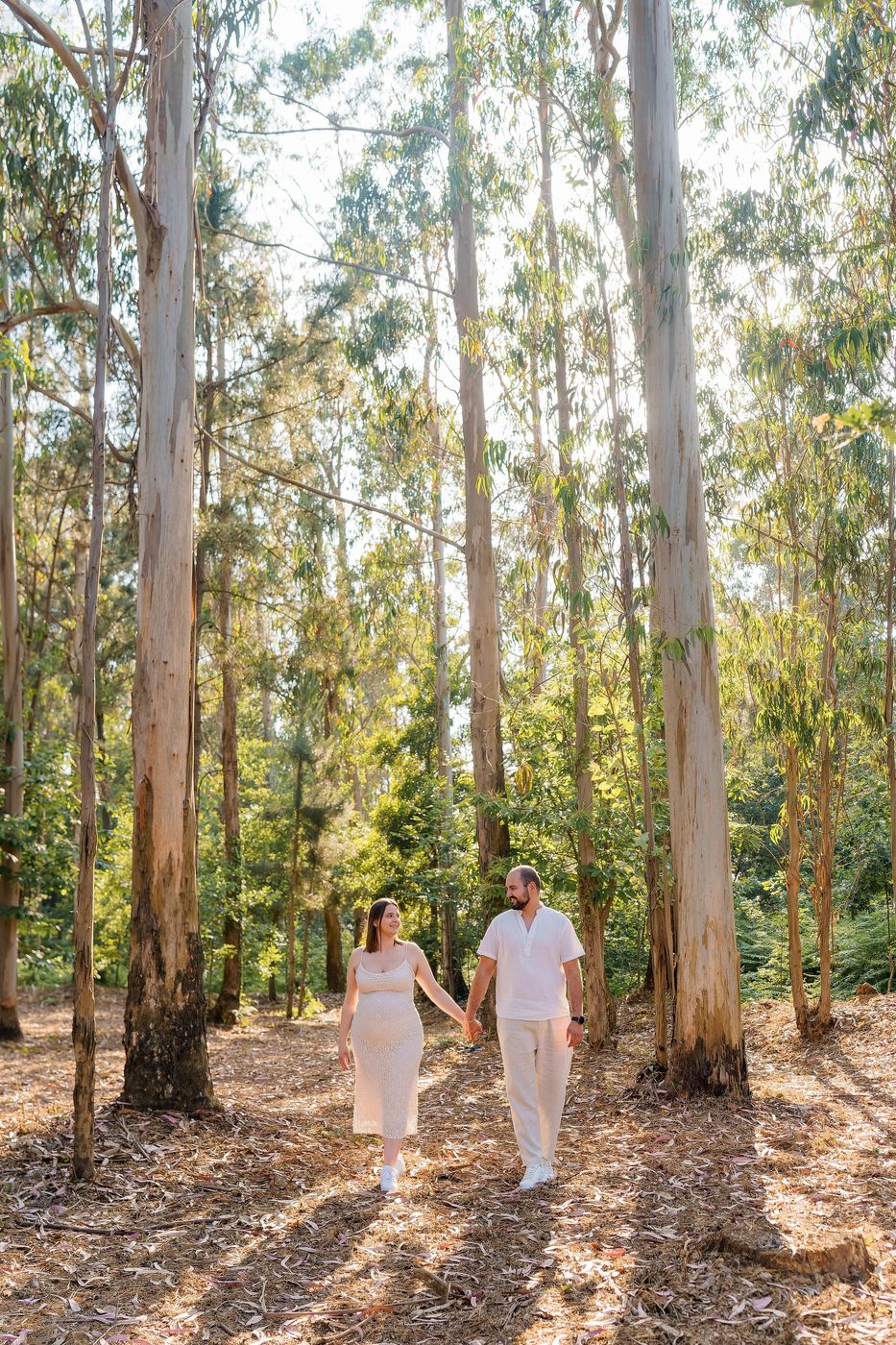 Couple walking hand in hand in a eucalyptus wood