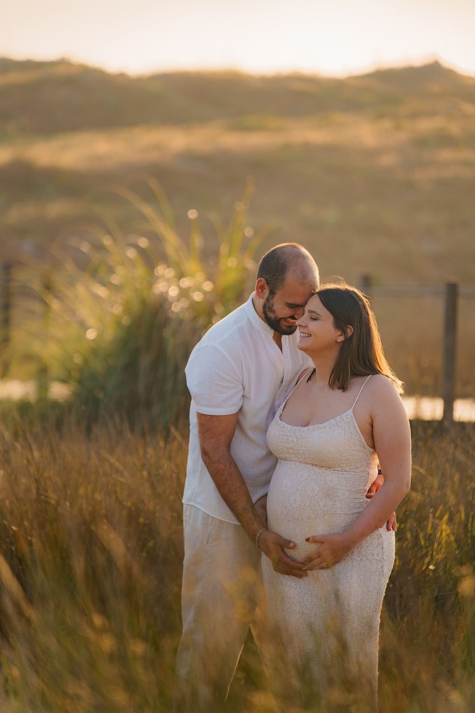Couple embracing in a field at the end of the day