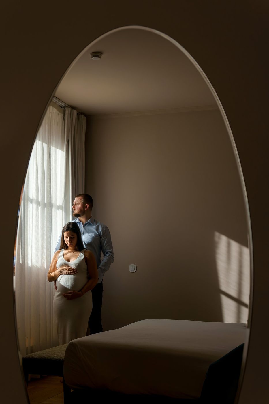 Couple reflected in an oval mirror