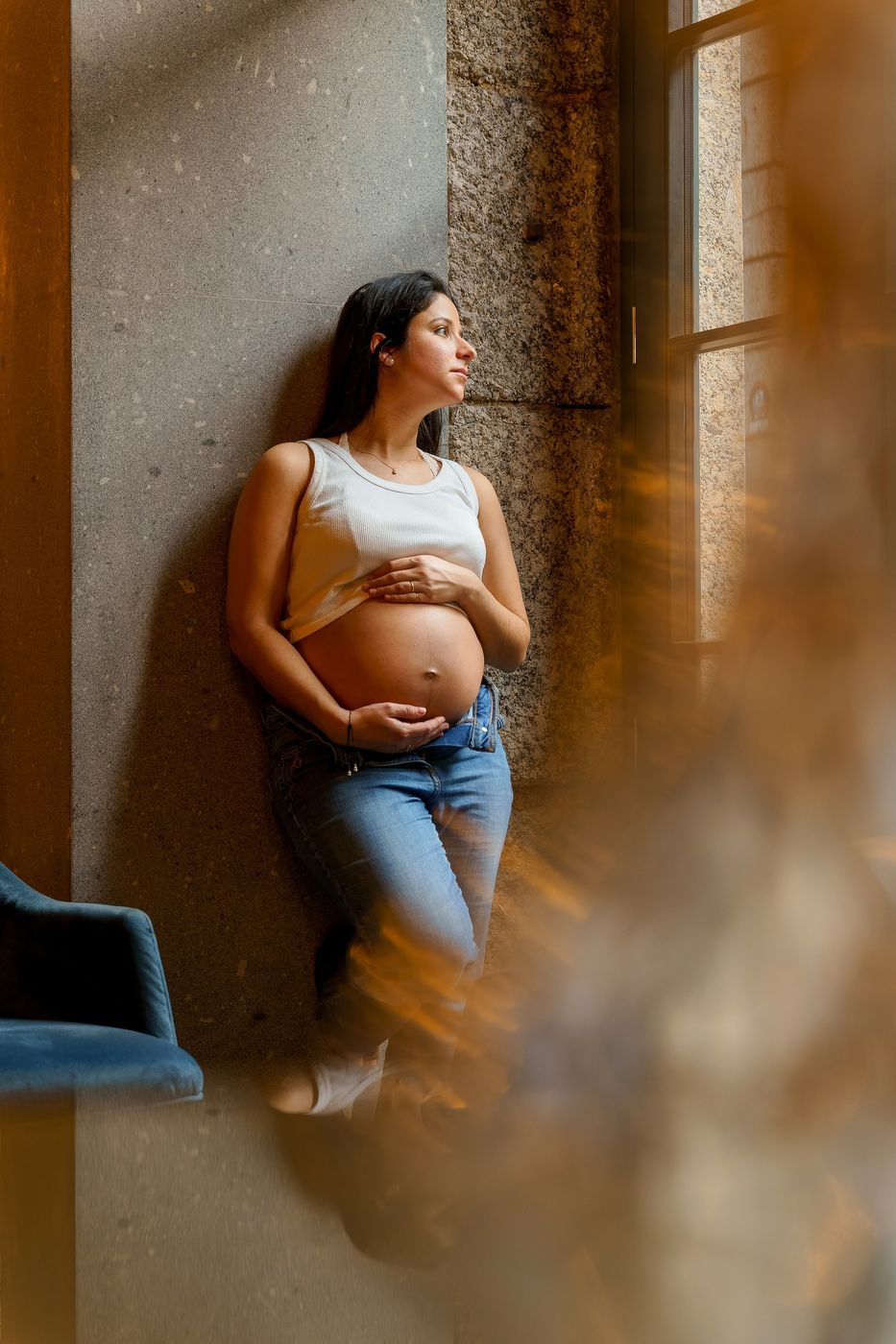 Mum-to-be leaning against a stone wall