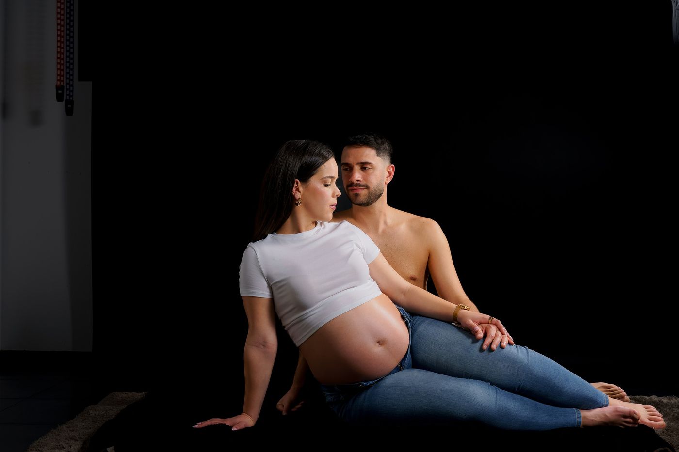 Couple sitting in the studio on a black background
