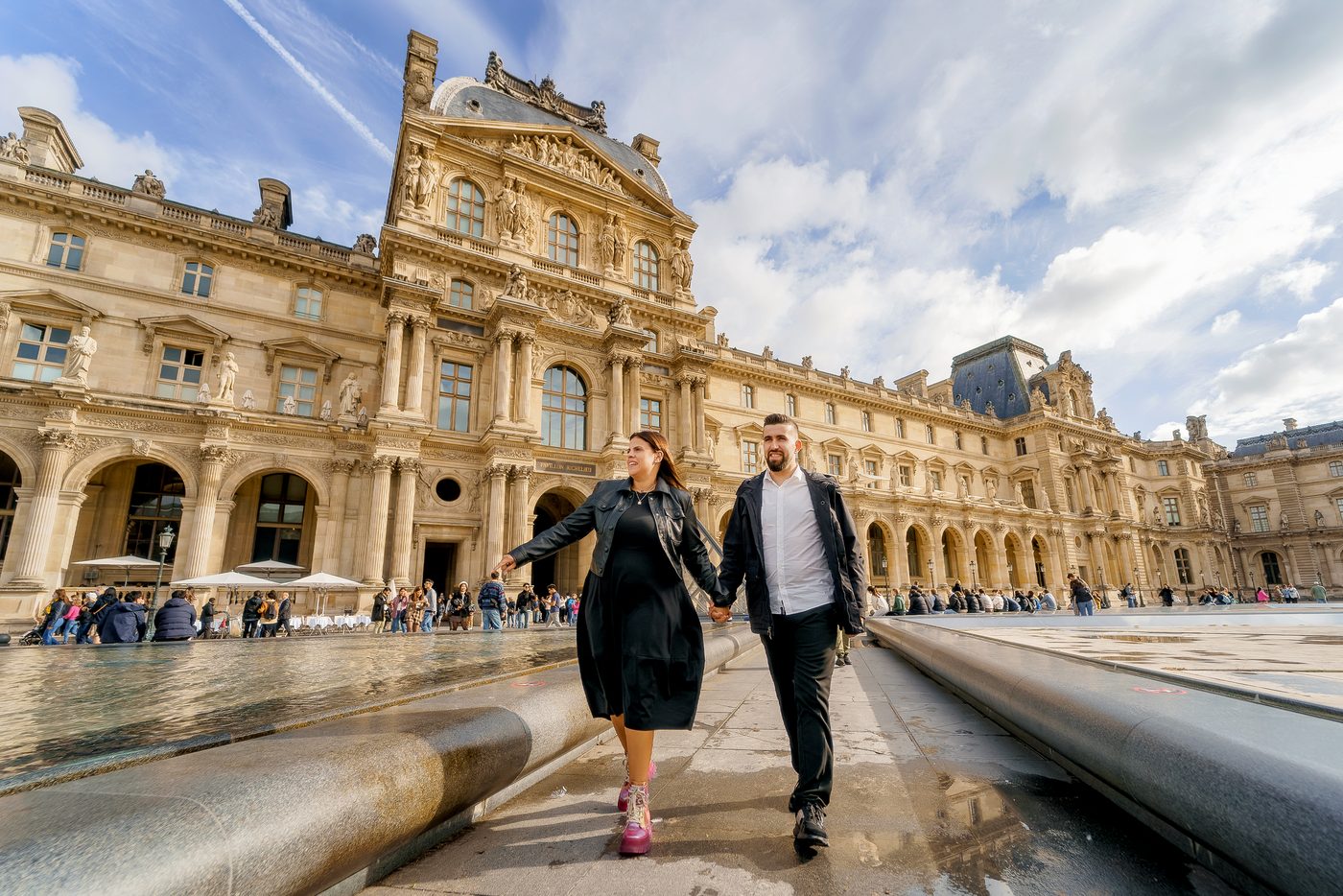 Casal de mãos dadas junto ao Museu do Louvre, em Paris